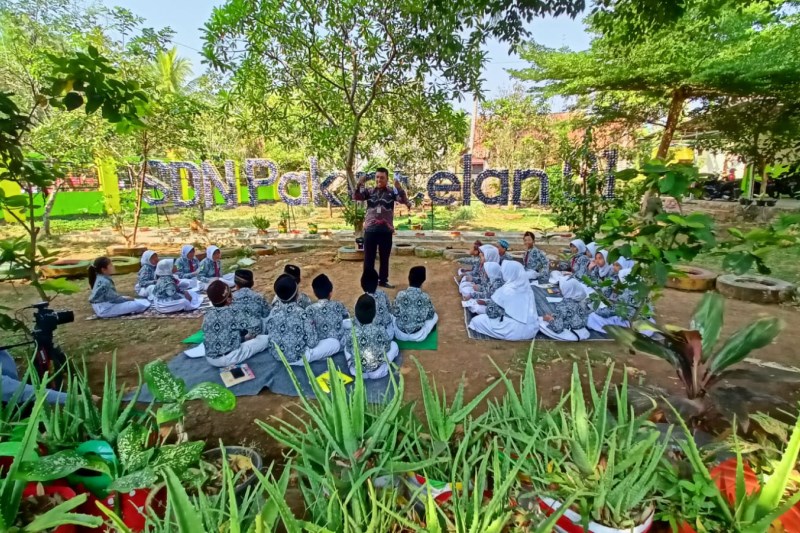 INOVATIF: Slamet Hari Pambudi  saat mengajar di SD Negeri Pakintelan 1 Kota Semarang. Ia memanfaatkan taman sekolah sebagai tempat belajar. (DOKUMEN PRIBADI)
