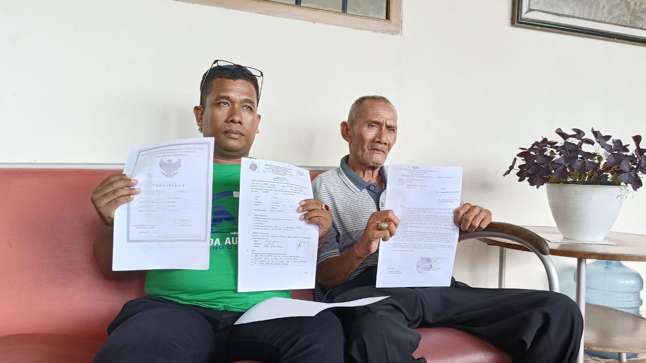 SENGKETA: Kakek Sunyoto (sebelah kanan) menunjukkan berkas kepemilikan sawahnya yang sedang berkonflik. (istimewa)