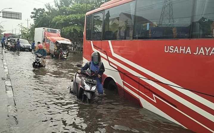 Suasana banjir di Pertigaan Jalan Kaligawe Raya dan Jalan Muktiharjo Raya, Selasa pagi (28/11). (Figur Ronggo Wassalim/Jawa Pos Radar Semarang)