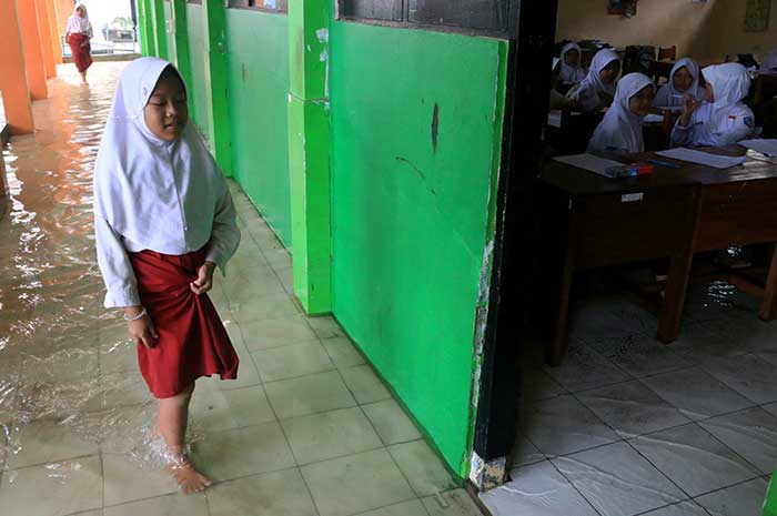 Para siswa SD Negeri Muktiharjo Lor mengerjakan PAS di tengah banjir, Selasa (28/11). NUR CHAMIM/JAWA POS RADAR SEMARANG