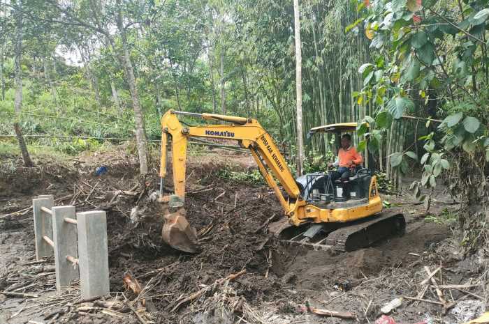 Tim BPBD saat melakukan pembersihan usai banjir bandang di jembatan Dukuh Desa Tajuk.&nbsp;Maria Novena/Jawa Pos Radar Semarang