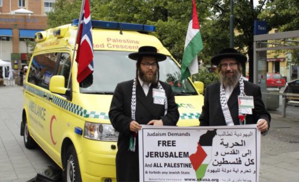 Sepasang rabbi berfoto di depan ambulan yang akan didonasikan