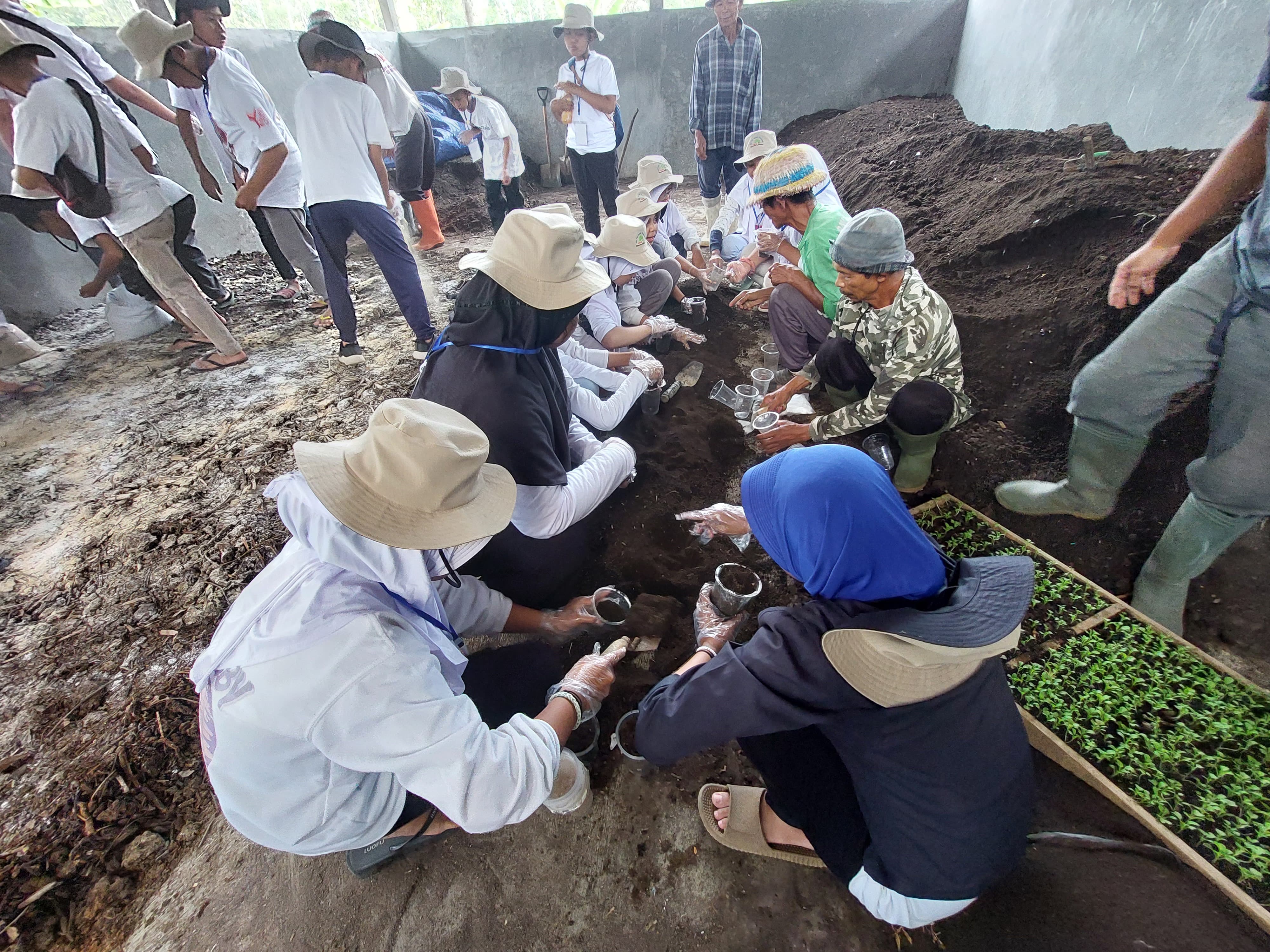 Wisatawan yang mencoba menanam menggunakan pupuk organik di Rumah Pupuk Dusun Tawang