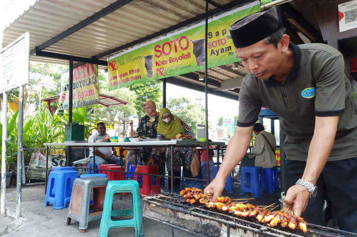 Makiran sedang membakar sate ayam khas Ambal, Kebumen, yang sudah ditunggu oleh pelanggannya. (PUPUT PUSPITASARI/JAWA POS RADAR SEMARANG)