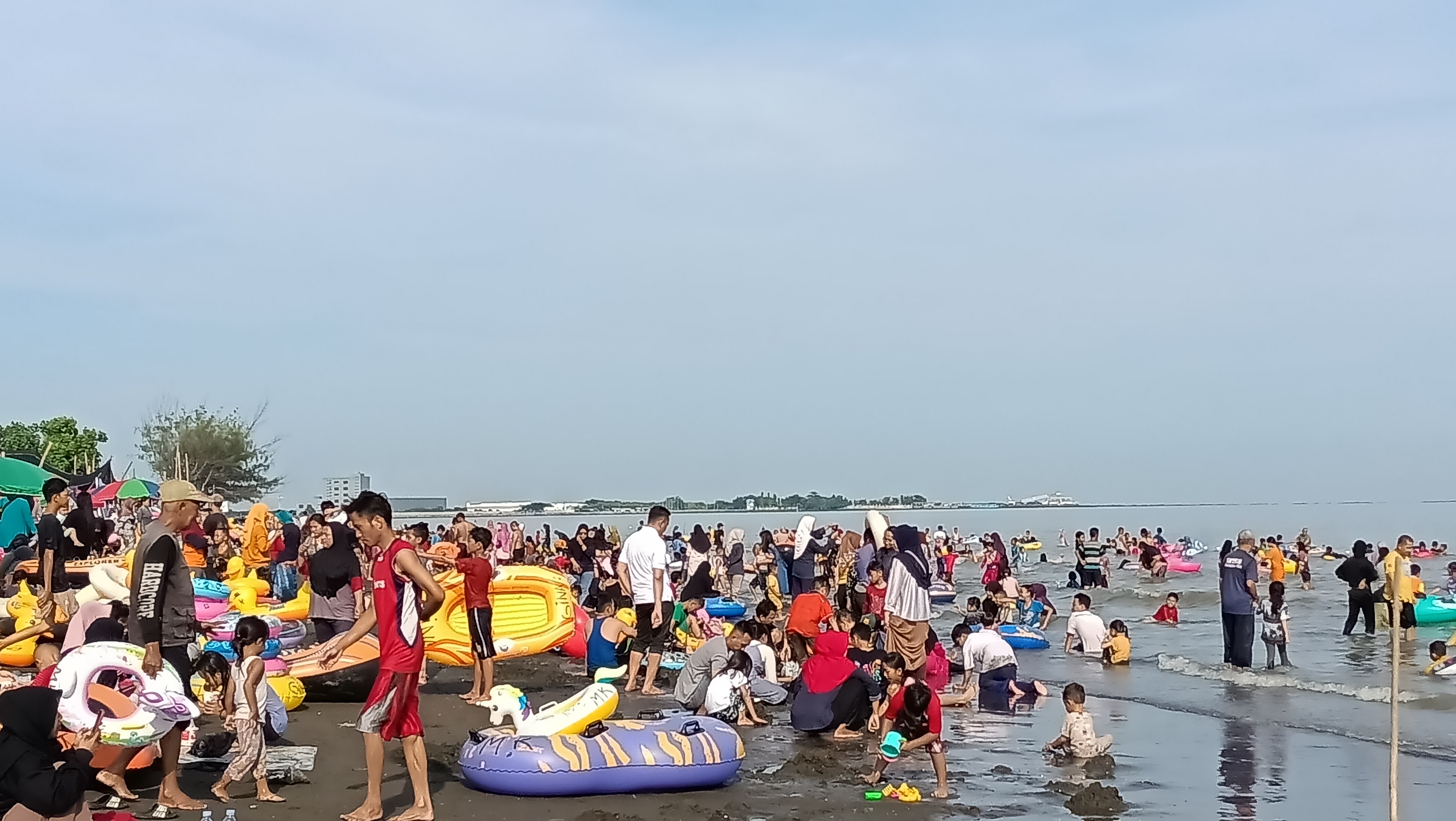 Ribuan pengunjung tampak asyik bermain air di Pantai Ngebum Kaliwungu Minggu (31/12).