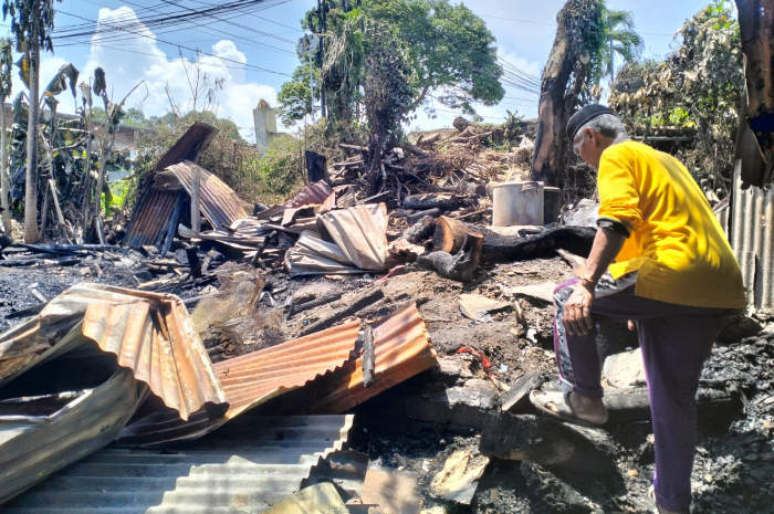 Kastono sedang memeriksa tempat usaha yang terbakar semalam. FIGUR RONGGO WASSALIM/JAWA POS RADAR SEMARANG