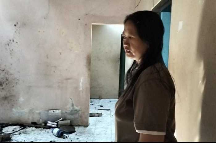 Herla Anggraini saat melihat rumahnya yang terkena longsoran dari rumah tetangganya yang tepat berada di atas rumahnya. (Figur Ronggo Wassalim/Jawa Pos Radar Semarang)