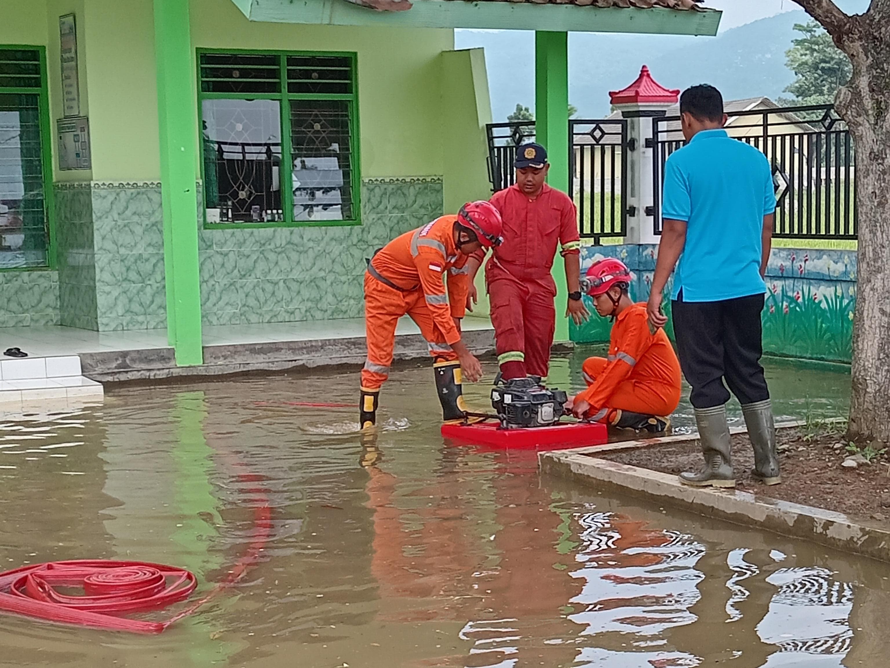Petugas Damkar Pos Ambarawa tengah melakukan penyedotan air