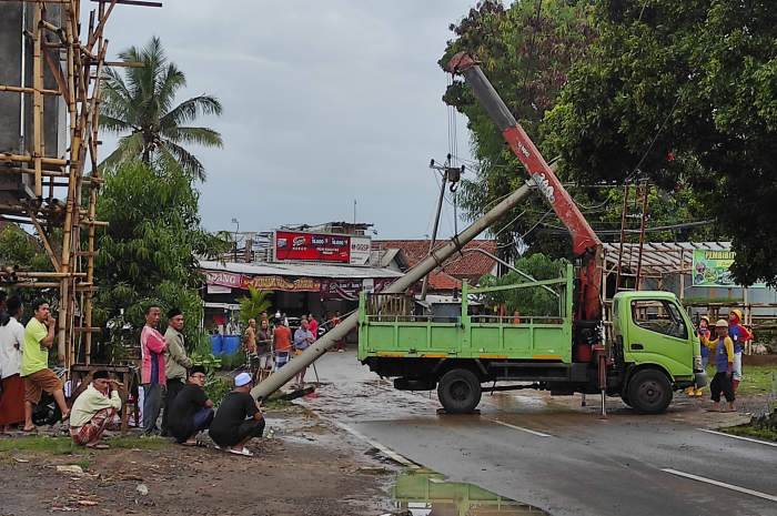 Proses evakuasi tiang listrik yang jatuh dan tersangkut di kabel listrik. NURFAIK NABHAN/Jawa Pos Radar Semarang