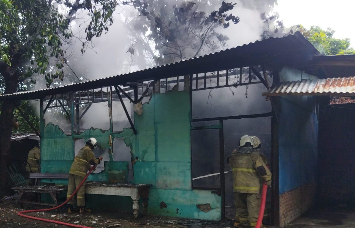Petugas memadamkan api yang membakar rumah Rumah di Jalan Muradi Raya, Kelurahan Kalibanteng Kulon, Semarang Barat, Kamis (18/1) sekitar pukul 13.45. (M Hariyanto/Jawa Pos Radar Semarang)