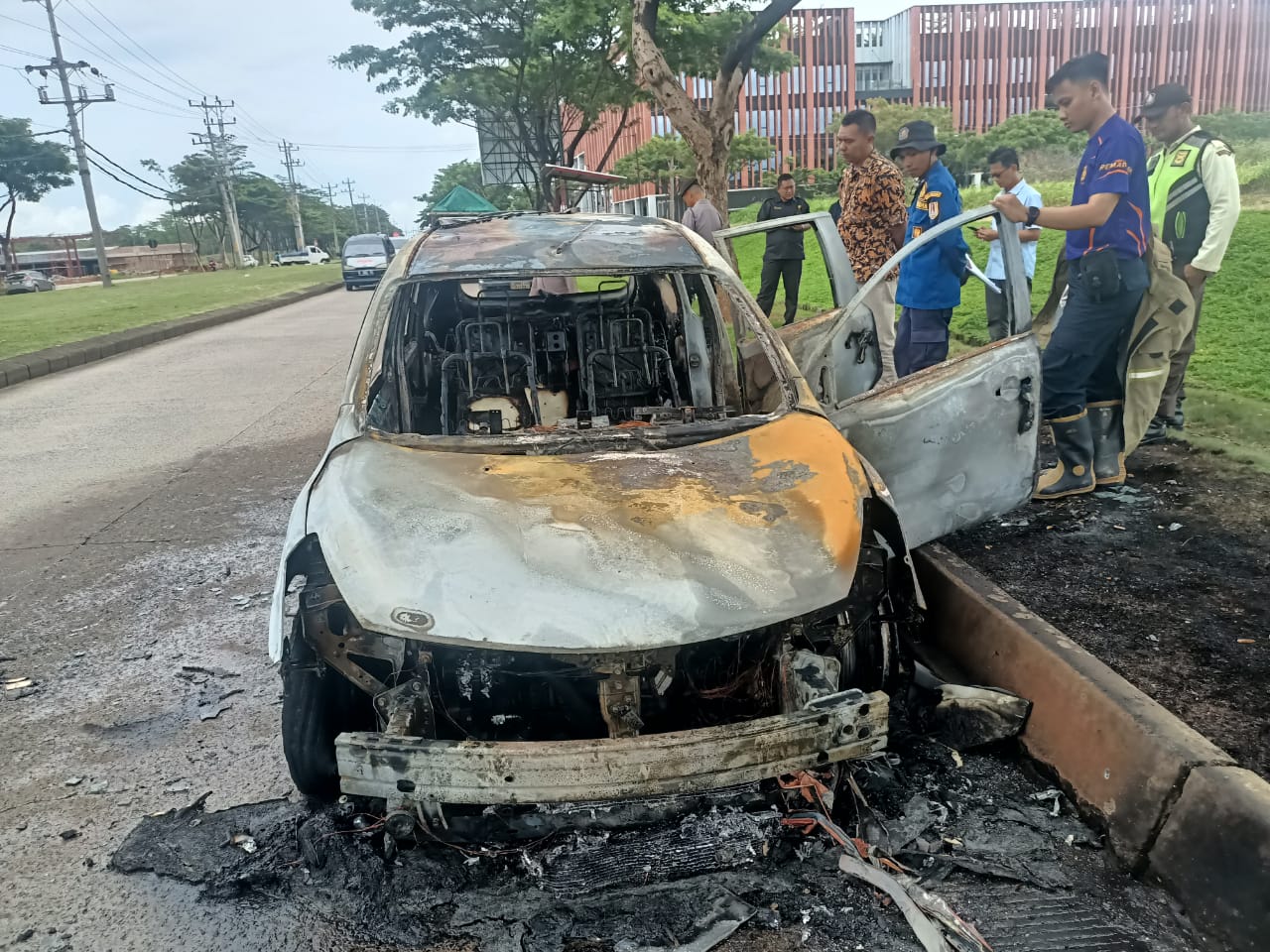 Sebuah mobil Nissan Grand Livina hangus terbakar saat melintas di Jalan Raya HM Hadi Soebeno Sosrowardoyo, persisnya di persimpangan dekat Bank BCA.