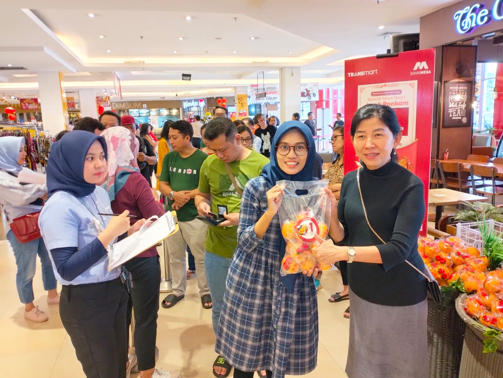Regional Head Bank Mega Semarang, Liviana Dewi menyerahkan jeruk ponkam kepada nasabah Bank Mega di Transmart Setia Budi Semarang, Minggu (4/2). FIGUR RONGGO WASSALIM/JAWA POS RADAR SEMARANG