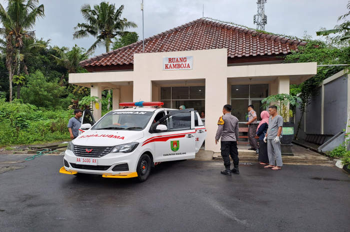 Usai proses otopsi, DP mayat laki-laki yang ditemukan di tepi jalan Payaman-Windusari langsung di bawa ke rumah duka dengan ambulans desa, Selasa (6/2). ROFIK SYARIF G P/JAWA POS RADAR SEMARANG