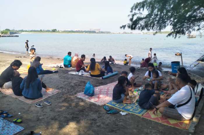Para pengunjung bersama keluarga sedang bercengkrama di Pantai Marina Semarang, Jumat (9/2) pagi.&nbsp;FIGUR RONGGO WASSALIM/JAWA POS RADAR SEMARANG