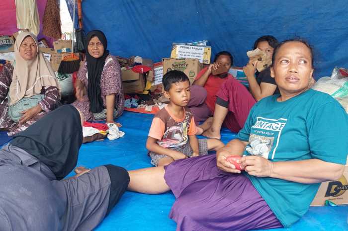 Warga Desa Wonoketingal, Kecamatan Karanganyar berdiam di posko banjir tepi jalan raya Pantura yang digunakan mengungsi. (Wahib&nbsp;Pribadi/Jawa Pos Radar Semarang)