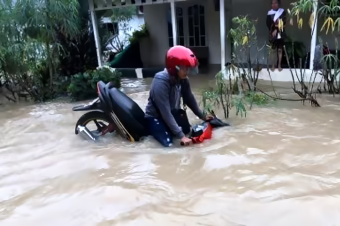Kendaraan bermotor terendam banjir saat melintas.