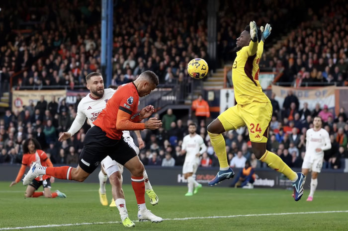Aksi kiper Manchester United Andre Onana saat mencoba menghalau bola dari pemain Luton.