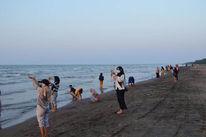Salah satu seorang wisatawan sedang memotret senja terindah di Pantai Indah Kemangi Kabupaten Kendal.