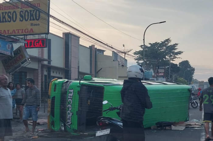 Sebuah prona penuh penumpang terguling setelah bertabrakan dengan minibus. Kejadian sekira pukul 06.10 pagi. (Dhinar Sasongko/Jawa Pos Radar Semarang