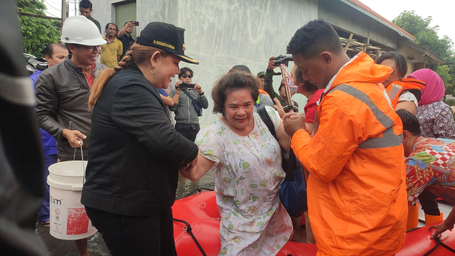 Wali Kota Semarang, Hevearita Gunaryanti Rahayu membantu proses evakuasi warga saat meninjau banjir di Kelurahan Kuning, Kecamatan Semarang Utara, Kamis (14/3).