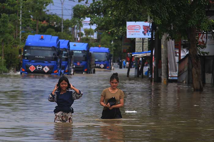 Warga terjebak banjir di Jalan Kaligawe, Kota Semarang Kamis (14/3). NURCHAMIM/JAWA POS RADAR SEMARANG