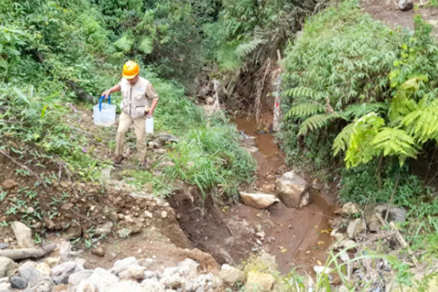 Petugas DLH Kabupaten Karanganyar mengambil sampel air dari kebun teh Kemuning. (Rudi Hartono/Radar Solo)