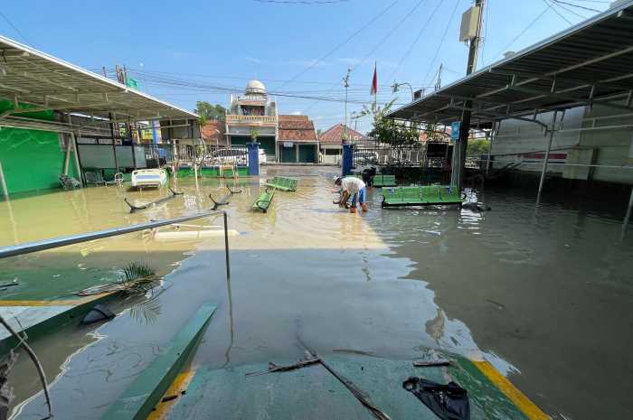 Petugas kesehatan membersihkan lingkungan Puskesmas Karanganyar yang terdampak banjir Senin (25/3). WAHIB PRIBADI/JAWA POS RADAR SEMARANG  &nbsp;