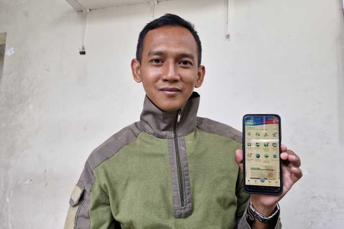 Nawan Priyambodo menunjukkan aplikasi Mobile JKN yang memudahkannya untuk berobat. PUPUT PUSPITASARI/JAWA POS RADAR SEMARANG