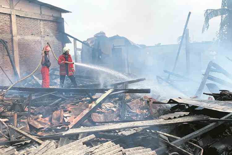 LUDES TERBAKAR : Petugas memadamkan kobaran api di Desa Caruban, Ringinarum.