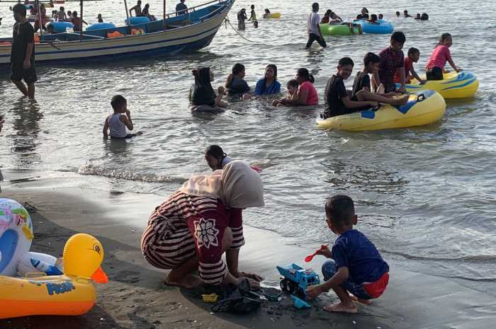 Wisatawan tampak senang bermain air di Pantai Ngebum saat libur Lebaran 2024. DEVI KHOFIFATUR RIZQI/ JAWA POS RADAR SEMARANG