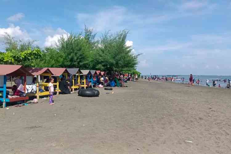 BERSANTAI: Para pengunjung bersantai dan menikmati keindahan Pantai Tirang, Minggu (14/4).