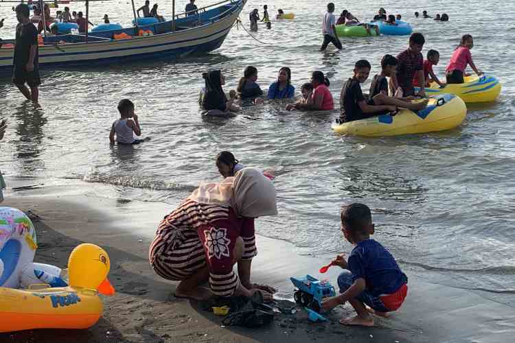 WISATA AIR : Wisatawan tampak senang bermain air di Pantai Ngebum saat libur Lebaran 2024.