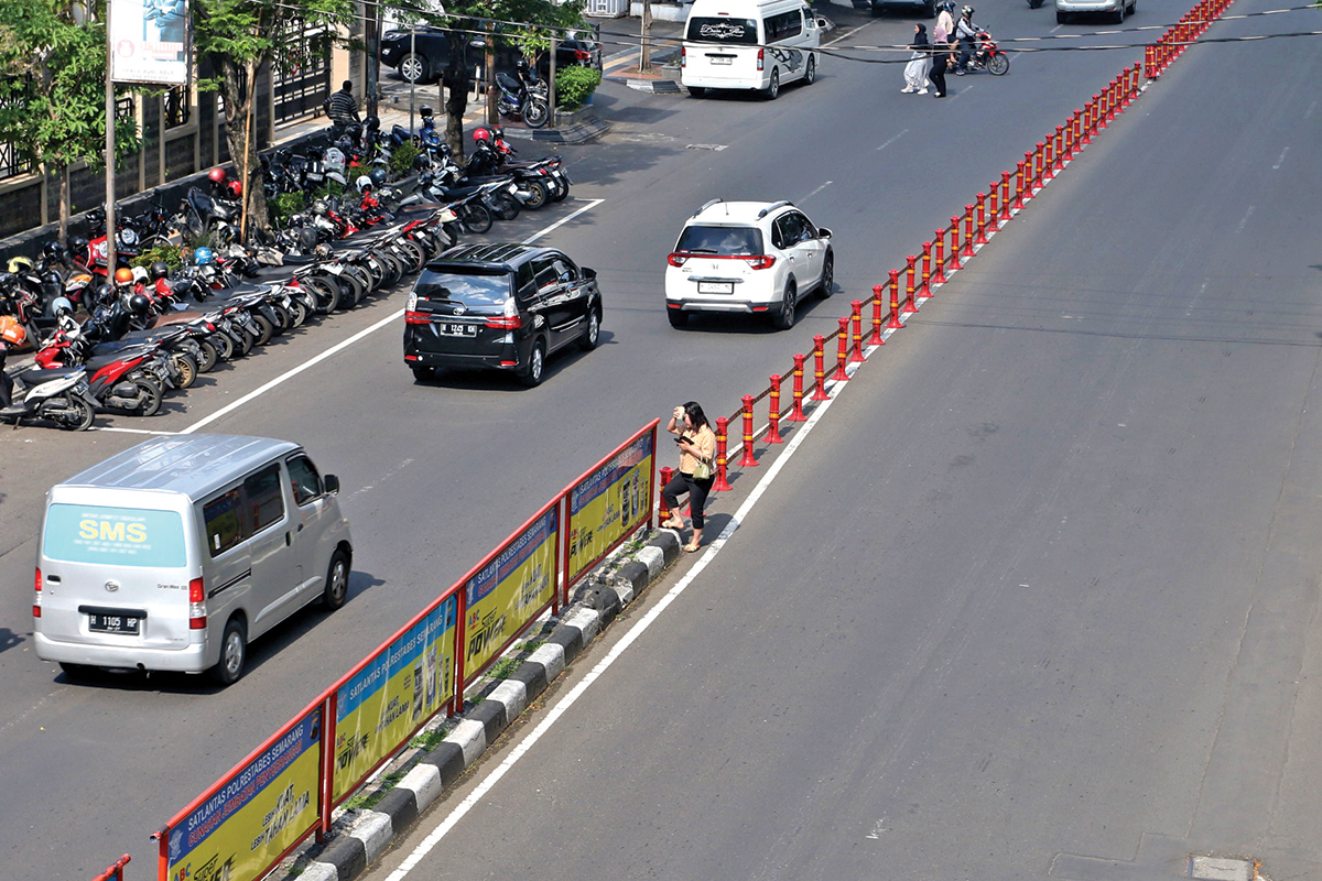 Sejumlah warga lebih memilih menerobos jalan raya dibandingkan menggunakan JPO karena dinilai lebih praktis. NUR CHAMIM/JAWA POS RADAR SEMARANG