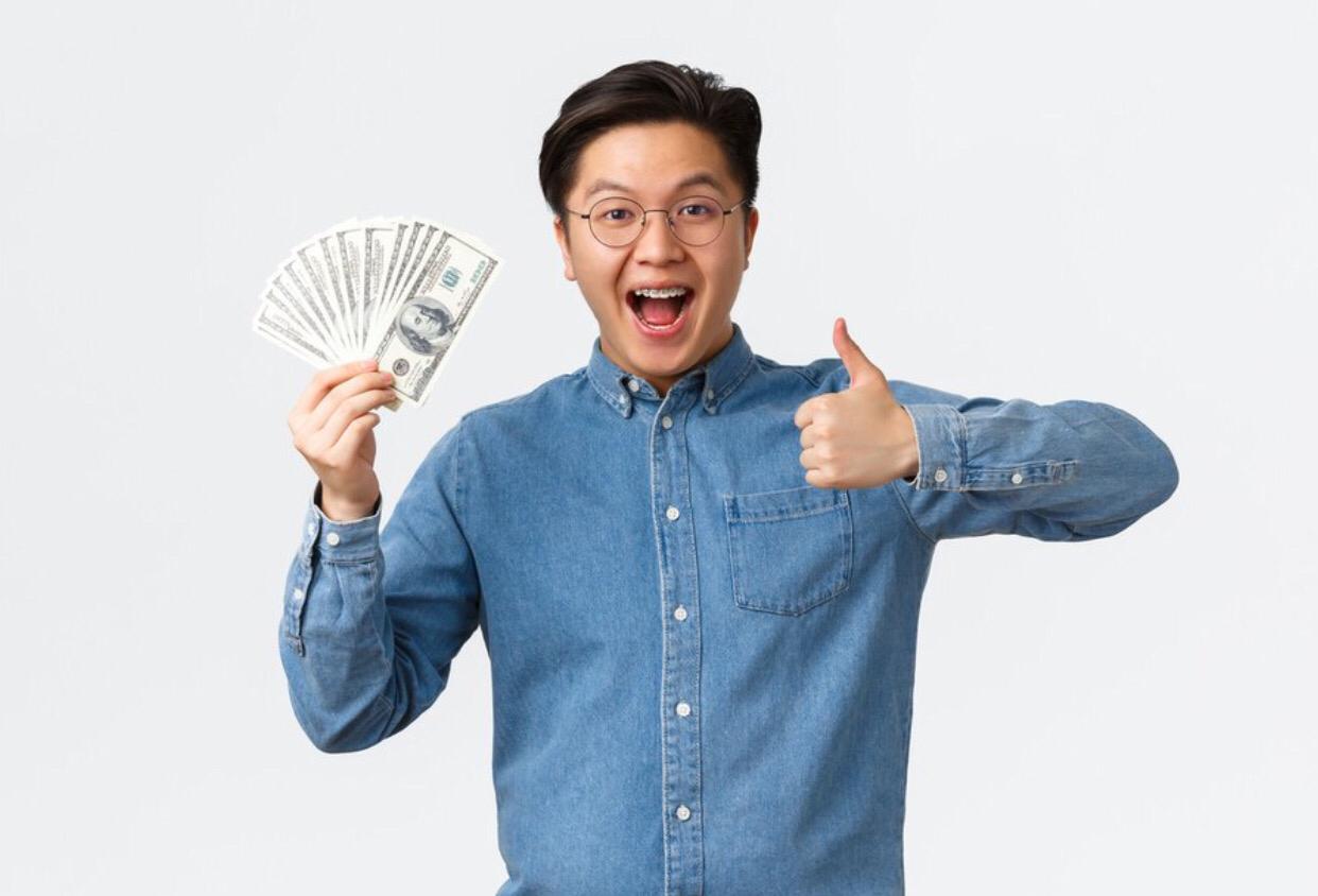 Ilustrasi : pria membawa segenggam uang kertas