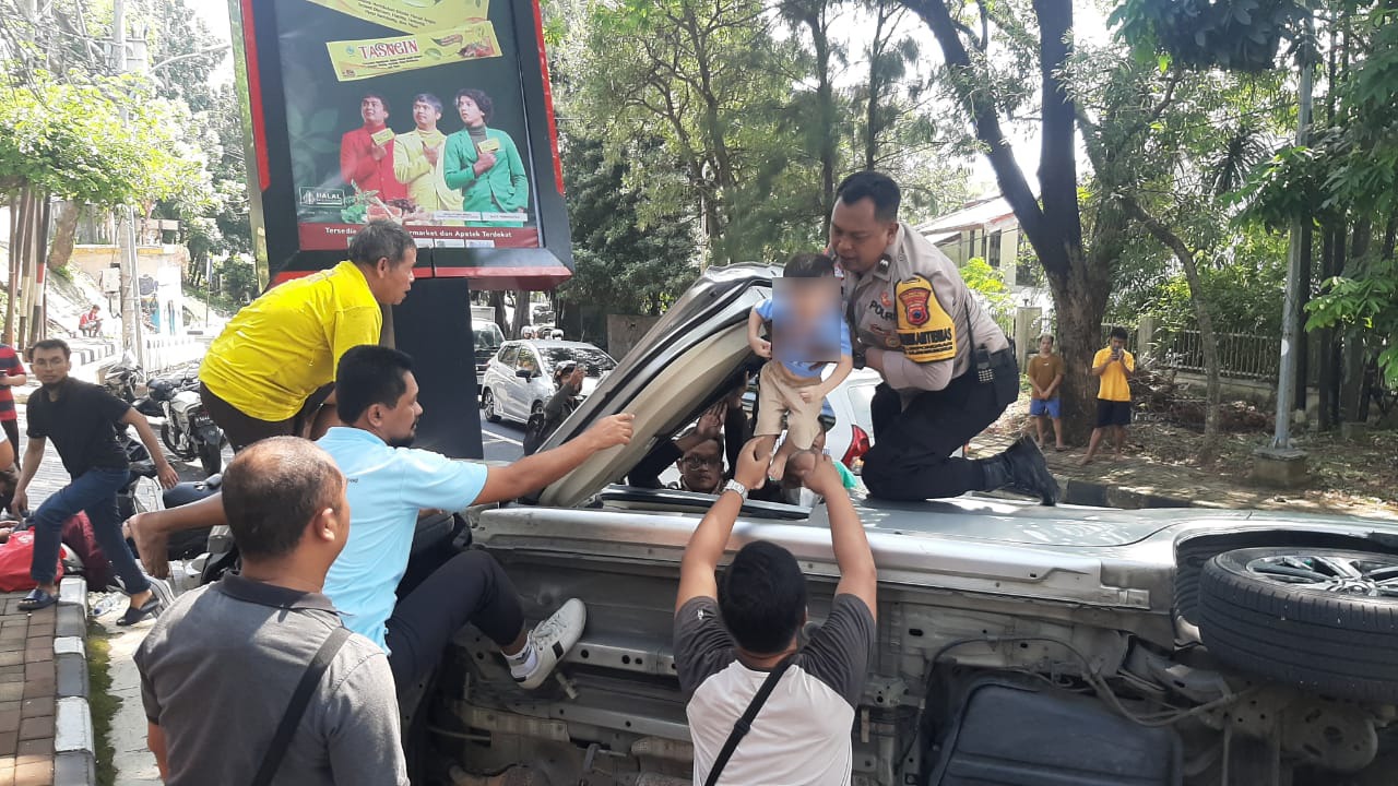 Polisi berusaha menyelamatkan korban kecelakaan Xpander di Semarang.