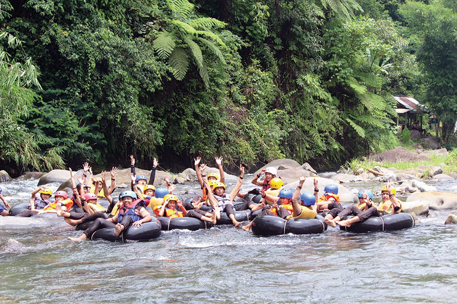 MELANCONG: Para wisatawan sedang menikmati wahana river tubing di Wisata Kali Paingan.