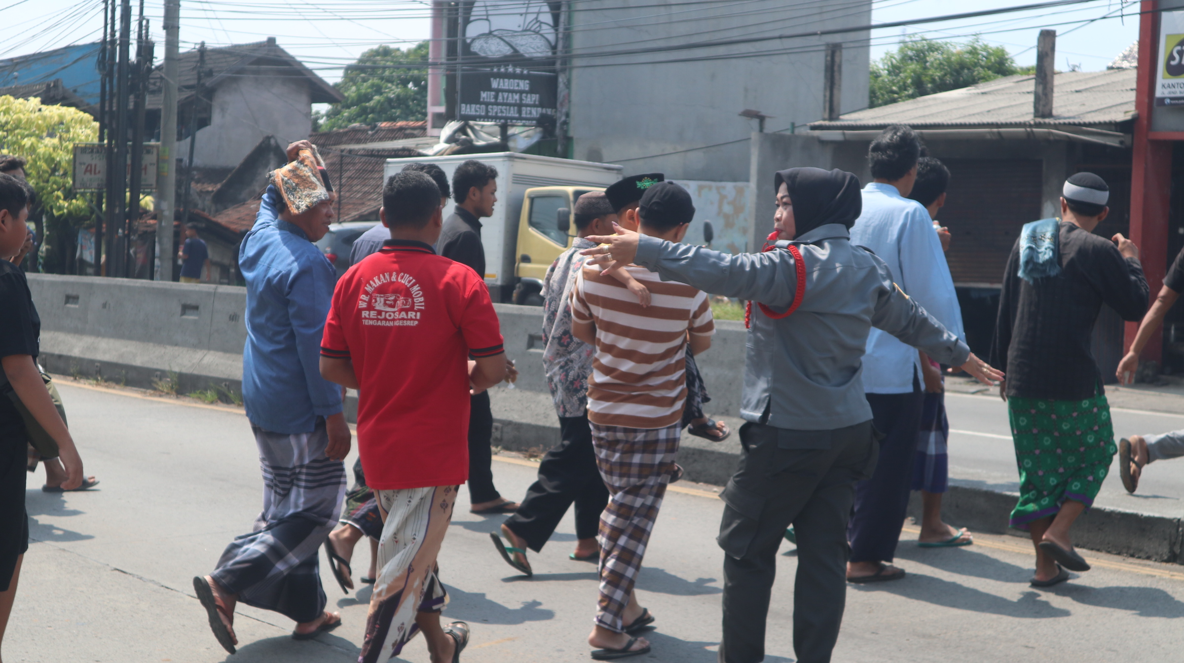 Salah satu anggota Srikandi Satlinmas Kabupaten Semarang saat membantu menyeberangkan jamaah sholat Jumat di Masjid Wahyu Langensari