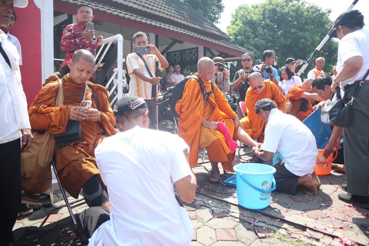 Warga umat Buddha membasuh kaki para Bikkhu Thudong sebagai penyambutan di Kabupaten Semarang. NURFAIK NABHAN/Jawa Pos Radar Semarang