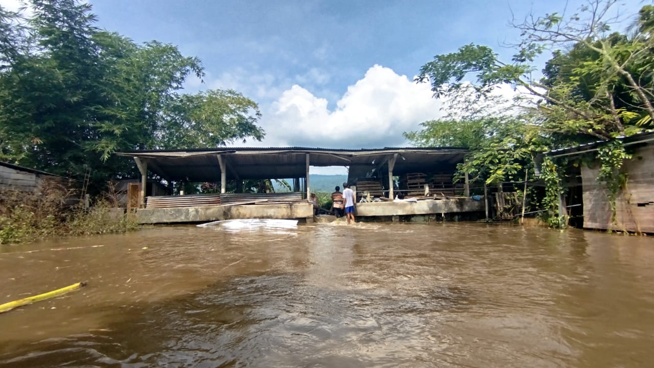 Sejumlah warga yang berusaha menutup titik tanggul jebol agar air tidak mengalir deras dari sungai