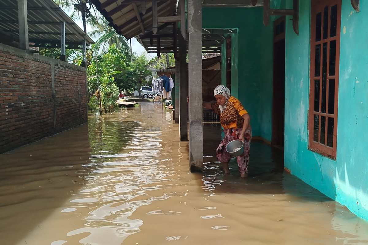 Sejumlah warga yang berusaha menutup titik tanggul jebol agar air tidak mengalir deras dari sungai. NURFAIK NABHAN/Jawa Pos Radar Semarang