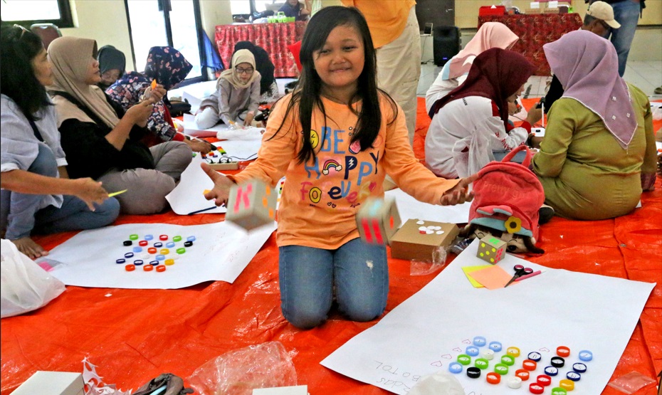 KREATIF: Puluhan warga Kelurahan Bendungan, mendaur ulang tutup botol dan kardus bekas untuk alat peraga edukasi, Jumat (21/6).