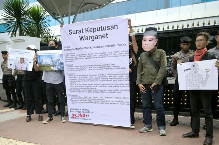 Aksi demo di depan Gedung Kemkominfo pada Rabu (10/7), massa membawa spanduk tertulis pesan &ldquo;Surat Keputusan Warganet&rdquo; meminta Budi Arie Setiadi mundur dari jabatannya.