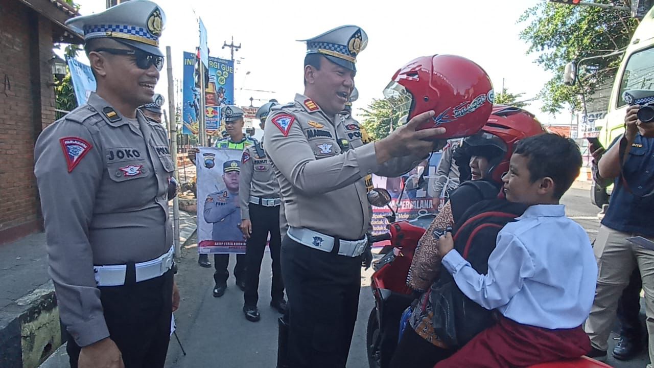 Polres Kendal membagikan helm gratis sebagai upaya sosialisasi keselamatan dalam berlalu lintas di traffic light Masjid Agung Kendal. DEVI KHOFIFATUR RIZQI/ JAWA POS RADAR SEMARANG