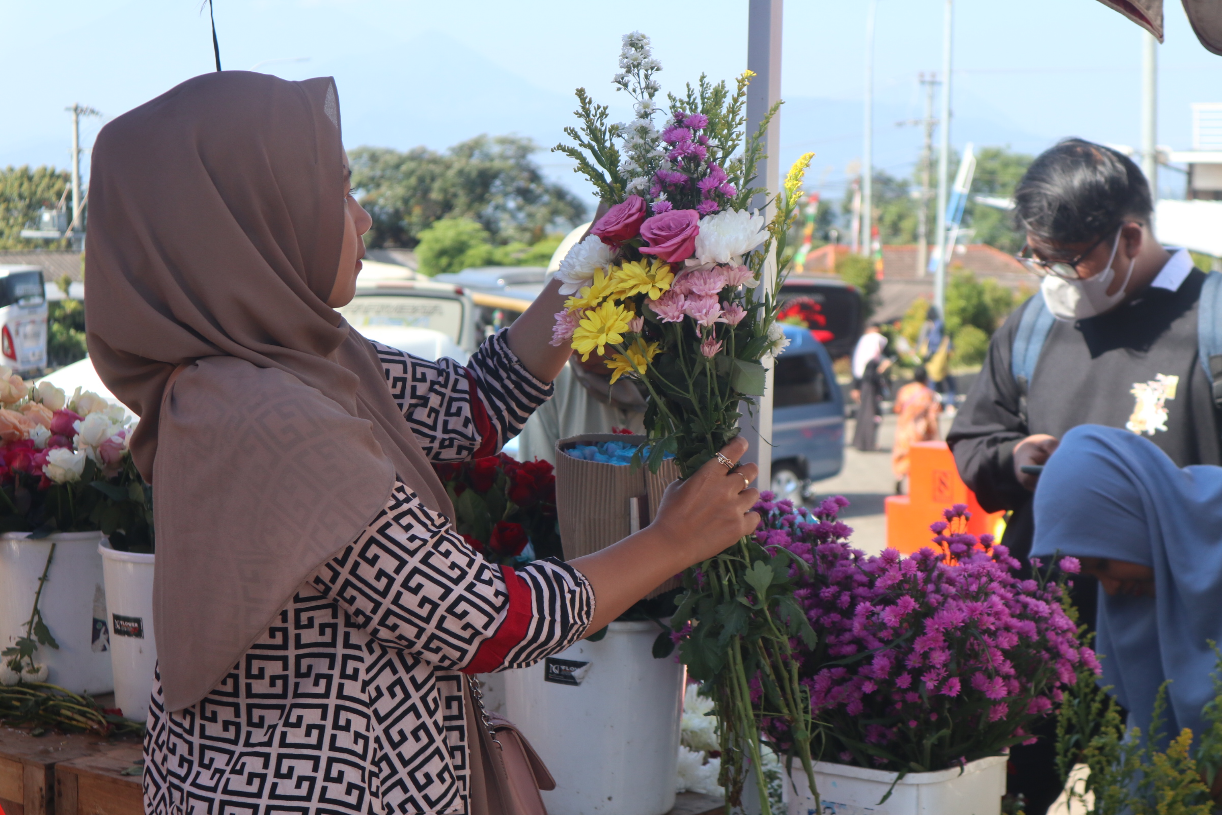 Salah satu pedagang bunga hias Bandungan saat menata bunga yang dipilih oleh pembeli
