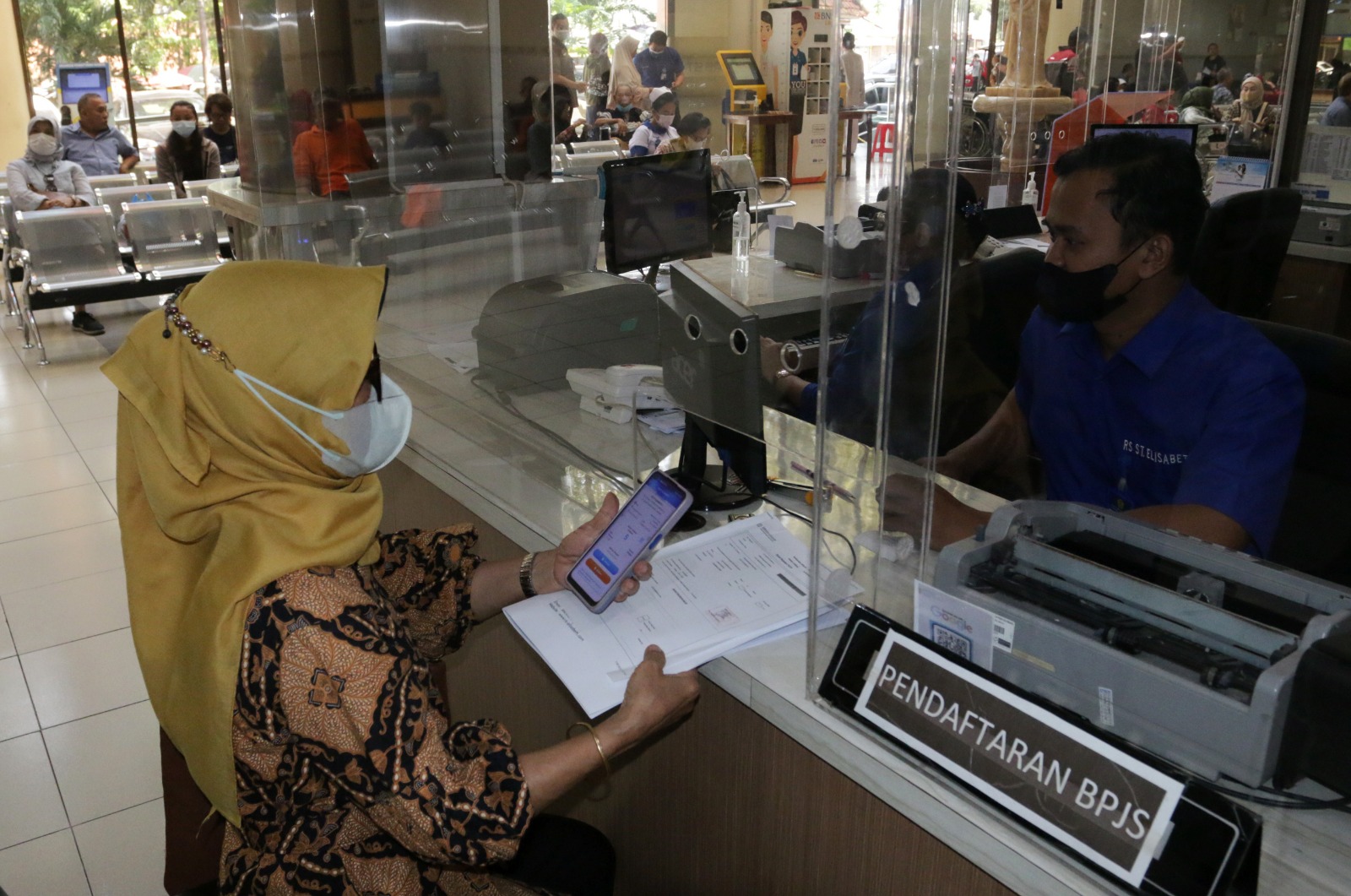 Peserta BPJS Kesehatan menyelesaikan administrasi dengan Program Jaminan Kesehatan Nasional (JKN) Dan Pelayanan Administrasi melalui Whatsapp (PANDAWA). Nurchamim/Jawa Pos Radar Semarang