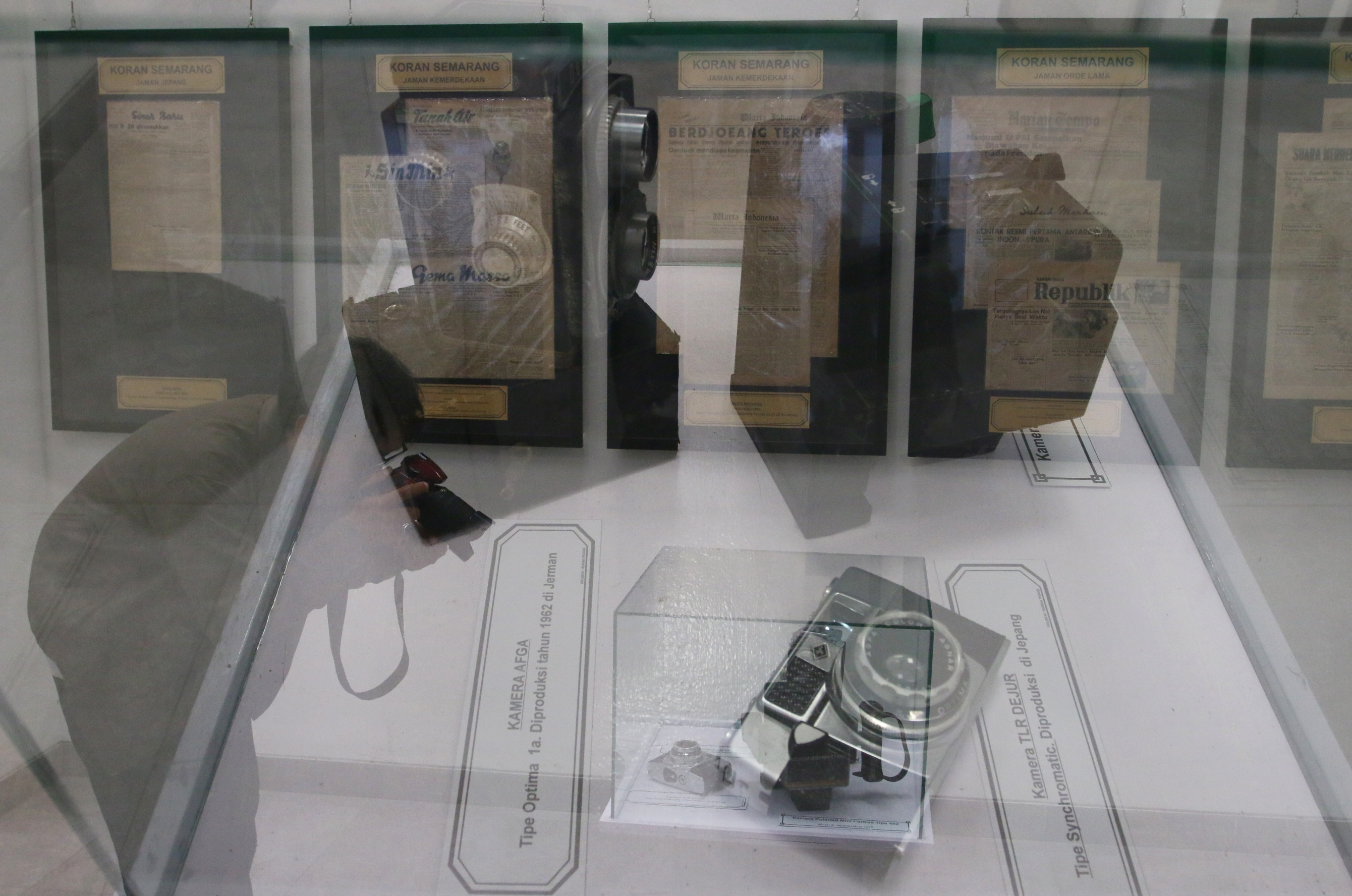 Seorang pengunjung momotret koleksi kamera kuno yang dipajang dalam pameran koran langka di Rumah Pohan Kota Lama Semarang, Jawa Tengah, Jumat (9/8/2024).