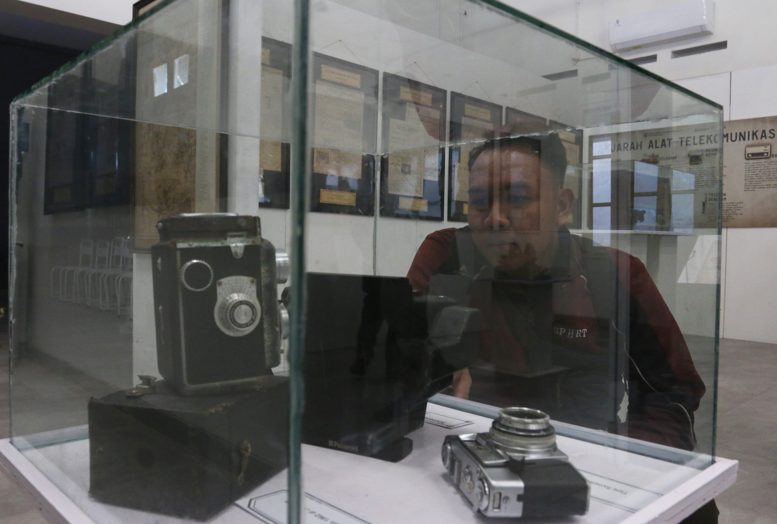 Seorang pengunjung mengamati koleksi kamera kuno yang dipajang dalam pameran koran langka di Rumah Pohan Kota Lama Semarang, Jawa Tengah, Jumat (9/8/2024)