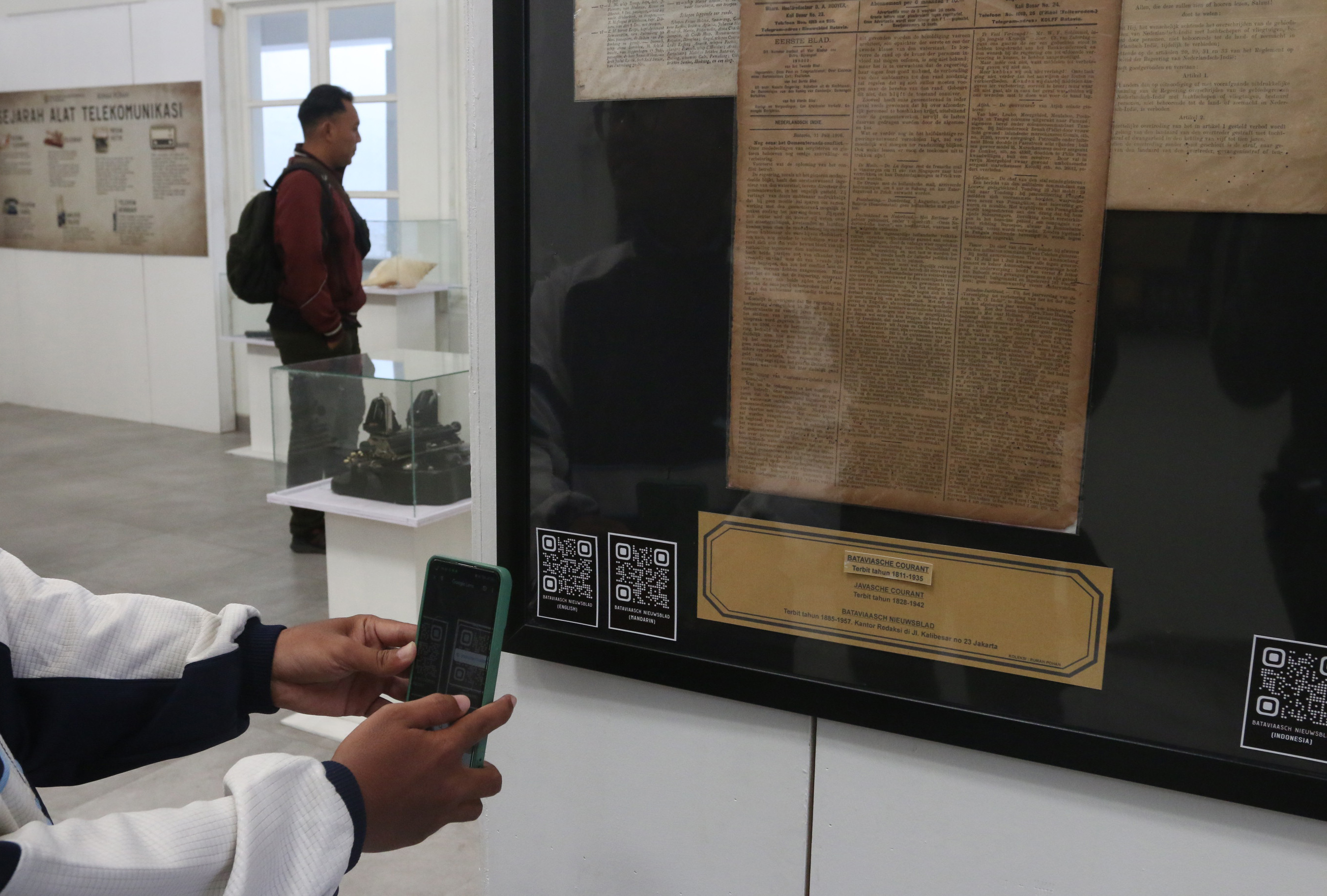 Seorang pengunjung membarcode koleksi koran langka yang dipajang dalam pameran koran langka di Rumah Pohan Kota Lama Semarang, Jawa Tengah, Jumat (9/8/2024).