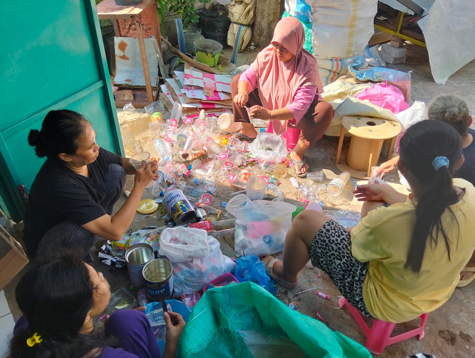 Kegiatan ibu rumah tangga di kelurahan Karanganyar gunung memilah barang bekas seperti botol bekas, gelas plastik dan kaleng bekas untuk kumpulkan dan di jual.
