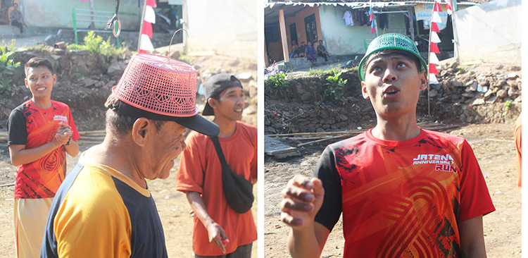 Mbah Tukirin dan Boby Gandi sedang berlomba menggantungkan  wakul ke lubang reng.